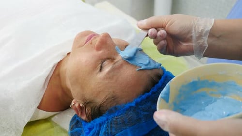 Cosmetologist Applying Facial Alginate Mask After Beauty Procedure in Modern Clinic