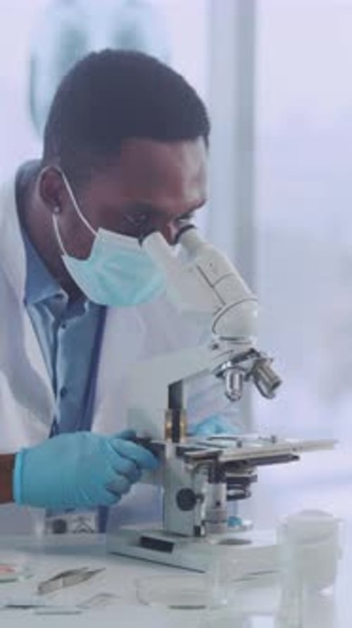 Man Using Microscope in Laboratory Setting, Medical Research