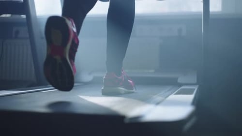 Legs of an Athlete Running on a Treadmill in the Gym
