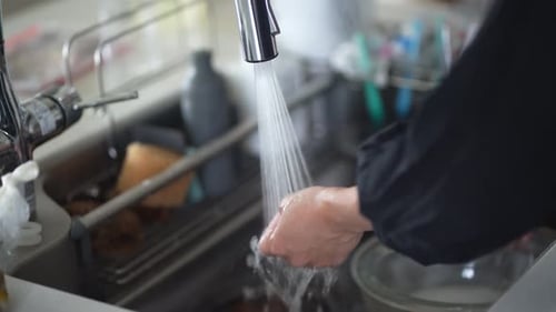 woman washing cooking utensils