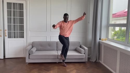Energetic Young Man Dancing Barefoot in Living Room