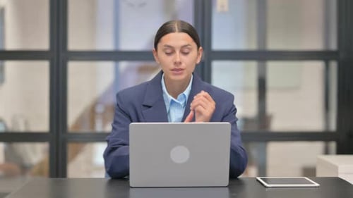 Young Woman with Wrist Pain Works on Laptop