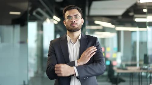 Confident Businessman in Modern Office with Arms Crossed