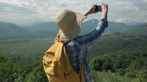 Woman Taking Picture in Mountain Landscape