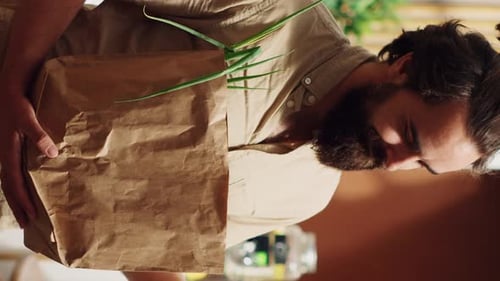 Un cliente de Vertical Video Shop utiliza una bolsa de papel biodegradable