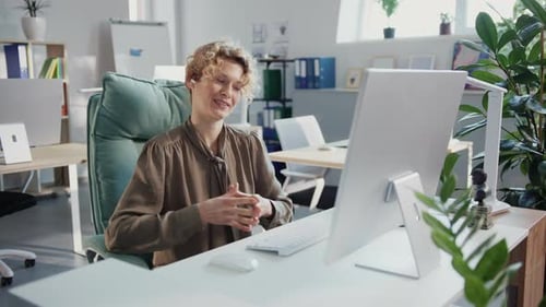 Cheerful woman video conferencing in an office setting