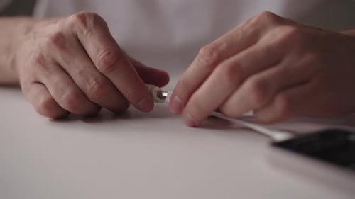 Close Up Hands Assembling Phone Adapter at Desk