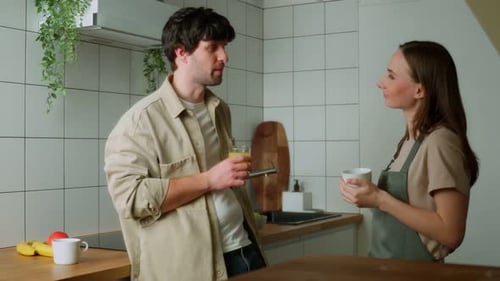 Couple Chatting and Drinking in Sunny Kitchen