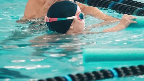 Der kleine Junge lernt mit seiner Mutter schwimmen und genießt die Wasseraktivitäten im öffentlichen Schwimmbad