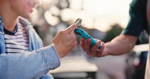 Two People Exchanging Cell Phones in Urban Setting