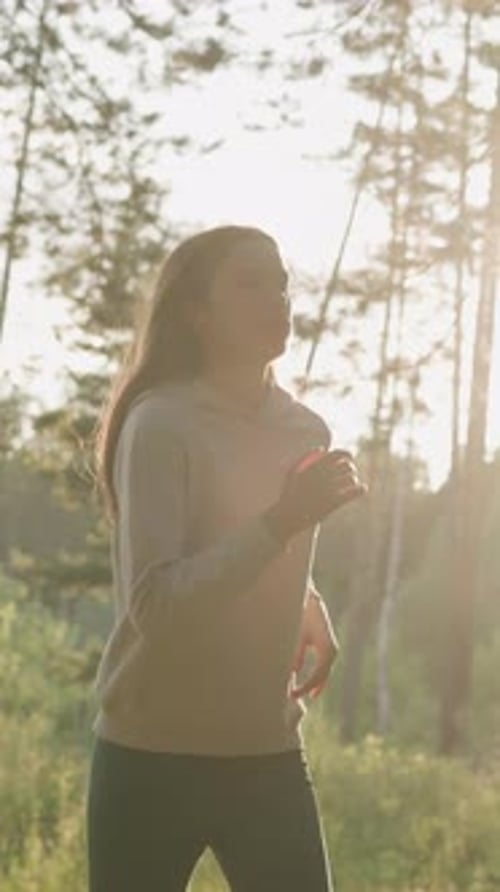 Mujer atleta corre en el bosque al atardecer