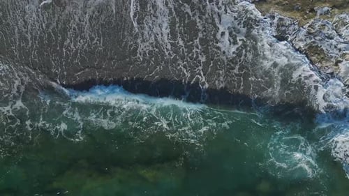 Luftbild eines atemberaubenden Strandes mit einzigartigen Sandmustern und kristallklaren, azurblauen Wellen, sanft
