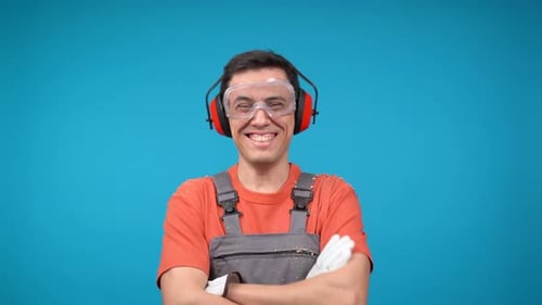 Smiling Man in Safety Gear Against Blue Backdrop