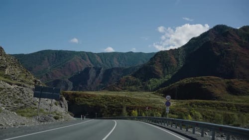 Enjoying a Scenic Drive on a Winding Mountain Road Following a Turquoise River Flowing Through the