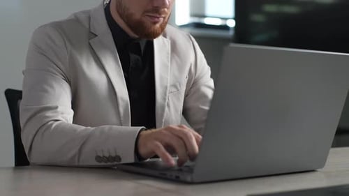 Cropped Shot of Focused Bearded Businessman in Suit Working on Laptop From Office Closeup of