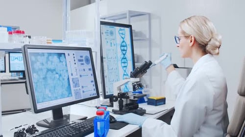 Scientist Works with Microscope in Bright Lab