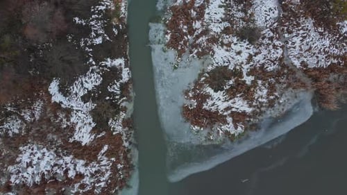 Aerial View of a Snow-Covered Forest with a River