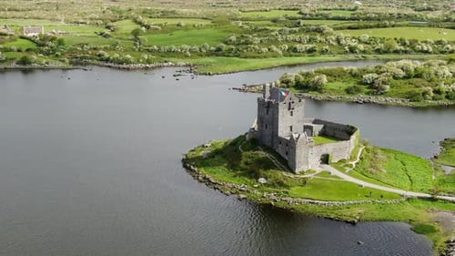 fantastic aerial shot in orbit over the medieval castle of Dunguaire on a sunny day, appreciating th