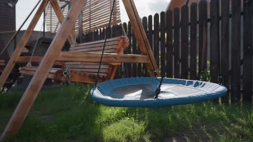 Peaceful Backyard Playground with Wooden Swing and Circular Nest Seat