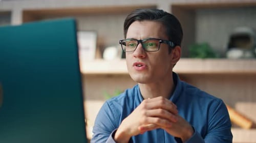 Young Man Video Conferencing On Laptop Computer Indoors