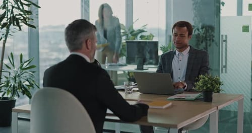 Zwei multiethnische Geschäftsleute arbeiten am Unternehmens- Desk zusammen, um einen Vertrag für zukünftige erwachsene Mitarbeiter zu lesen
