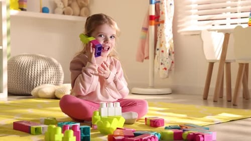 Little girl playing with toys on floor in playroom