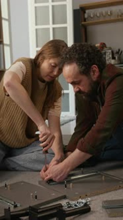 Couple Cooperating while Assembling Flatpack Furniture Piece at Home