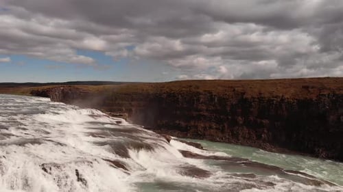 Powerful Waterfall Flowing Through Rocky Canyon