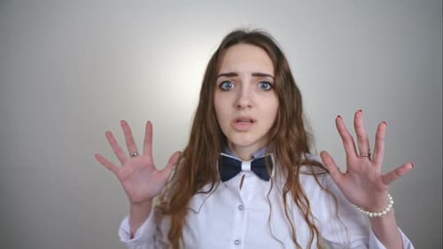 Worried Woman Raises Hands in Fright