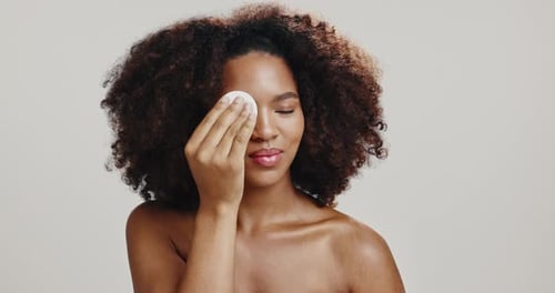 Face, woman and pad for makeup, studio and foundation for skin with cosmetics, routine and African