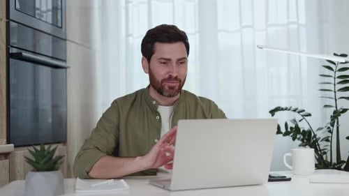 Man Video Conferencing On Laptop At Home