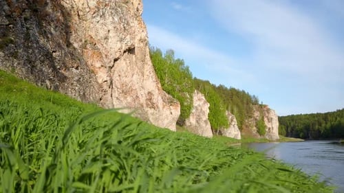 River Flanked By Cliff and Grass