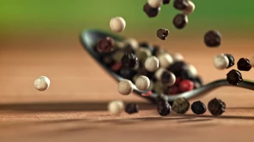 Pfefferkörner fallen auf den Tisch, gefilmt mit einer Hochgeschwindigkeitskamera mit 1000 Bildern pro Sekunde