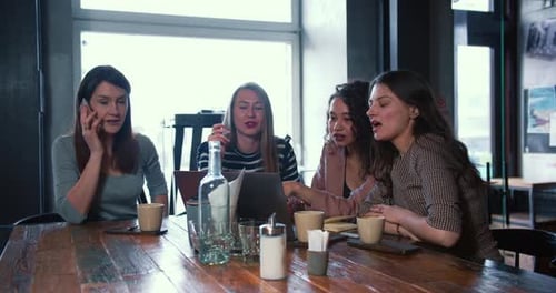 Young Women Work Together in Cafe Setting