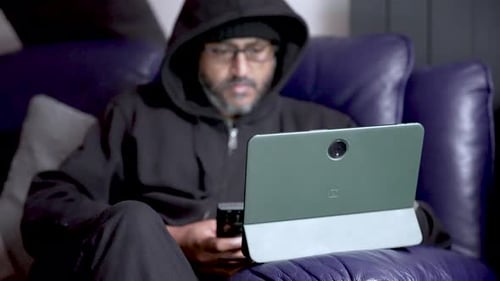 Man Using Tablet and Phone While Relaxing on Couch