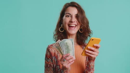 Excited Woman With Phone Holding Fan of Cash