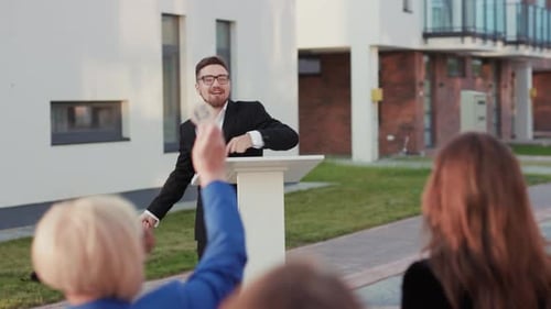 Auctioneer Speaking to Crowd at Suburban Real Estate Auction
