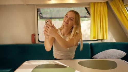 Woman Smiling and Taking a Selfie in Camper