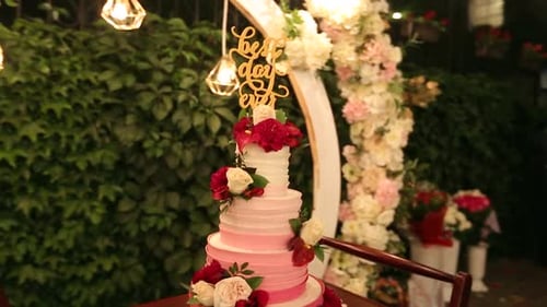 Wedding Cake with Best Day Ever Sign on Green Garden Decorated for Wedding Party at Night White and