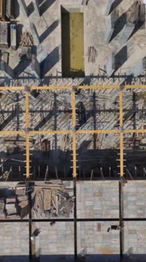 Los ingenieros de vídeo vertical supervisan la construcción de la pared de un nuevo piso en una obra muy transitada