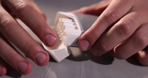 Mann mit Zigarettenschachtel am grauen Tisch, Nahaufnahme