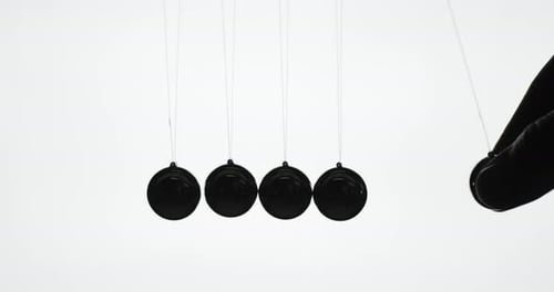 Die Silhouette von Newton-Kugeln, eine Reihe von Metallkugeln, die das Gesetz der Energieeinsparung demonstrieren