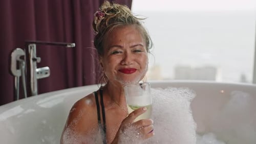 Woman Relaxes in a Bubble Bath with a Drink