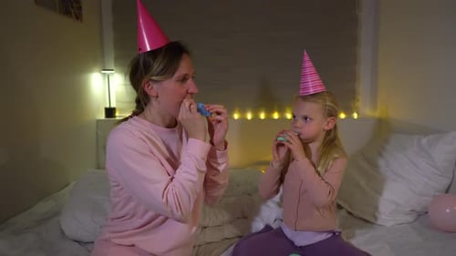 Woman and Girl Celebrate with Balloons and Party Blowers