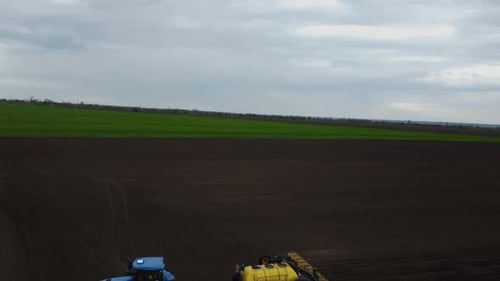 Blue tractor OA working on the field in Ukraine