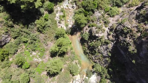 Mountain stream in the forest with colorful waters. Aerial view rising with rotation Green River. Sp