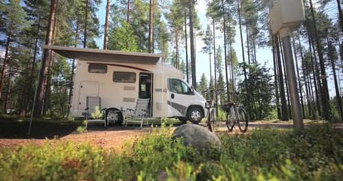 Camper Van and Bicycles at Campsite in Forest