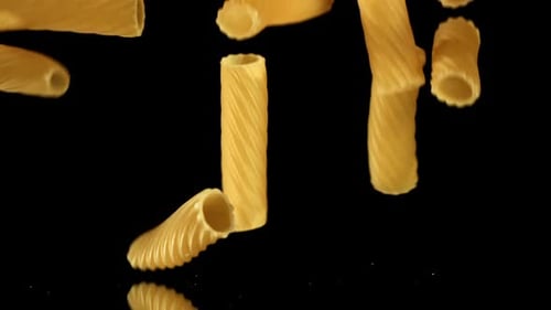 Rigatoni Pasta Falling on Black Background Food Concept
