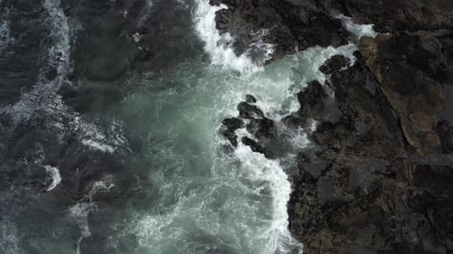 Waves Crashing on Rocky Shoreline Aerial View