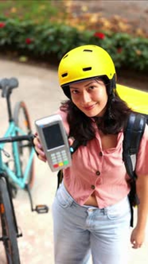 vertical Asian delivery woman accepting credit card payment